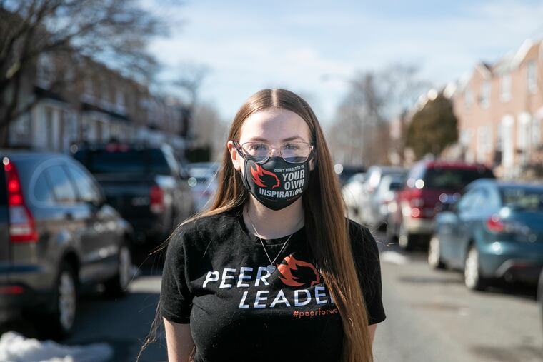 Colleen McCaffrey, a senior at Northeast High School, helps her peers fill out financial aid forms for college. Across the country, the number of students filling out federal financial aid forms is down more than 9% from last year.