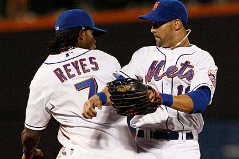 New York's Jose Reyes and Angel Pagan celebrate after wrapping up their shutout of the Phillies. (Kathy Willens/AP)