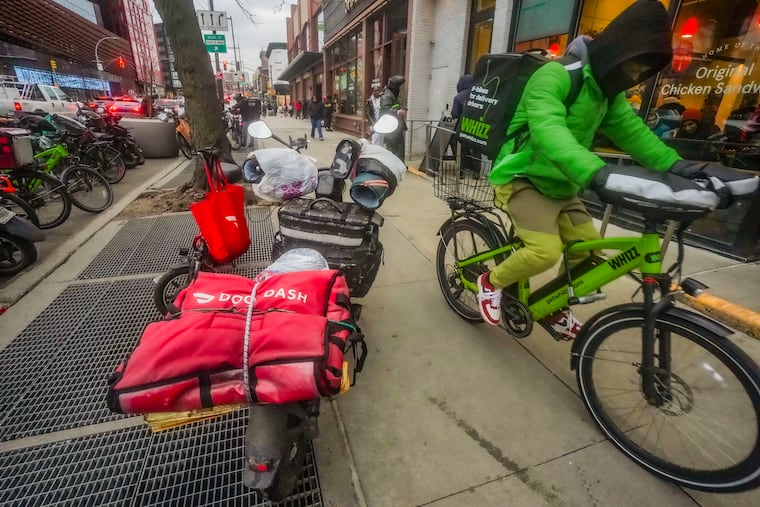 A food delivery worker rides off after a pickup from a fast-food restaurant on Brooklyn's Flatbush Avenue in January 2024. A minimum-wage law in New York City meant to protect food couriers resulted in food-delivery apps moving the in-app tip feature, making it less likely for customers to leave a gratuity.