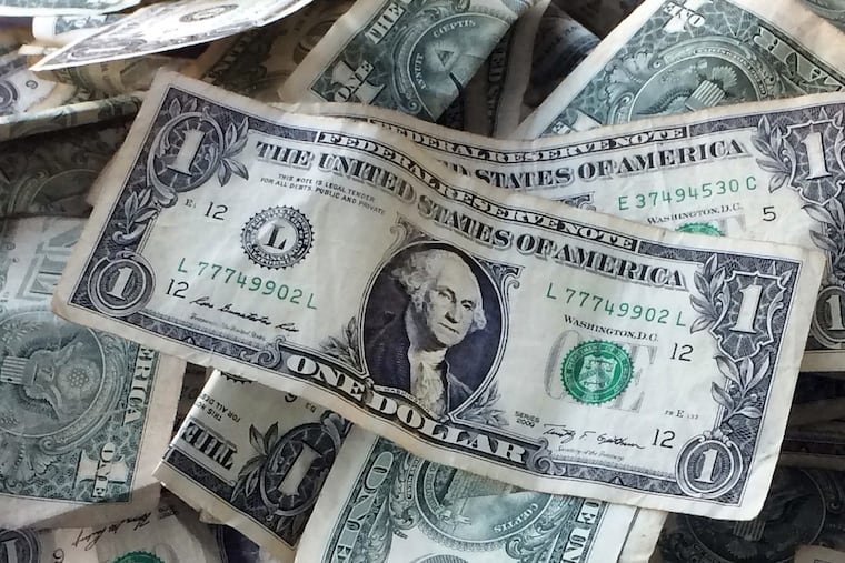 Dollar bills stack up in this October 2016 photo from New York. For those seeking income now from their equity and bond portfolios, the authors of the Independent Adviser for Vanguard Investors newsletter offer some fund suggestions.