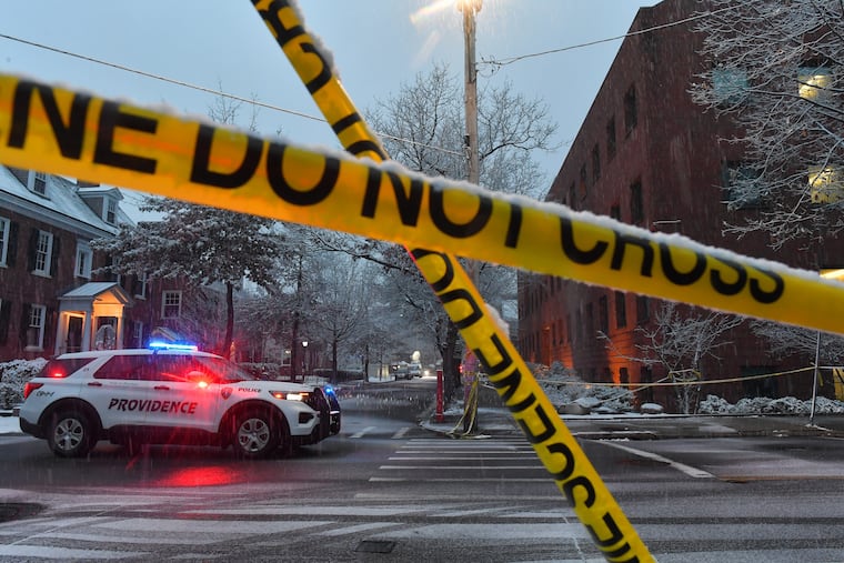 A police vehicle rests at an intersection near crime scene tape at Brown University, Sunday, Dec. 14, 2025, in Providence, R.I., following a Saturday, Dec. 13, 2025 shooting at the university.