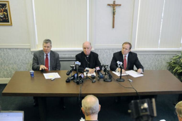 Anthony Flynn, left, attorney for Delaware's Catholic Diocese of Wilmington, Rev. W. Francis Malooly, center, bishop of the diocese, and Robert Brady, right, bankruptcy attorney for the diocese, address media during a news conference on Monday. (AP Photo/ Steve Ruark)