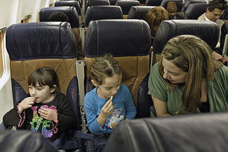 Gena Catanese (left), 5, with her sister Isabella, 6, and her mother, Melanie. The mock flight was an experience shared with her father and another sister, too. (Elizabeth Robertson / Staff Photographer)