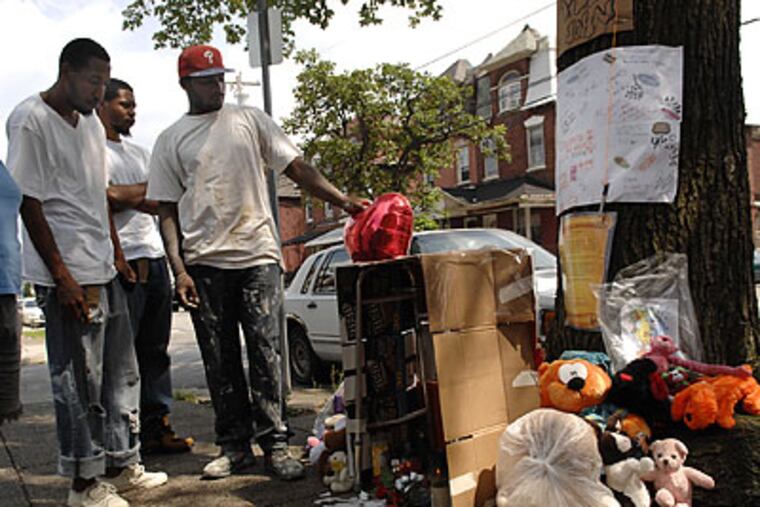 Friends gathered at a memorial for John Hightower, who was killed on Redfield Street in West Philadelphia on Saturday. (Alyssa Cwanger/Staff Photographer)