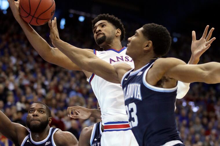 Kansas forward Dedric Lawson, center, rebounds against Villanova forward Jermaine Samuels, right, during the first half of an NCAA college basketball game in Lawrence, Kan., Saturday, Dec. 15, 2018. (AP Photo/Orlin Wagner)