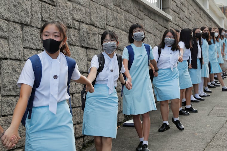 Students form human chain outside the Maryknoll Convent School in Hong Kong, Friday, Sept. 6, 2019. Hong Kong leader Carrie Lam said Thursday that the decision to withdraw an extradition bill that sparked months of demonstrations in the semi-autonomous Chinese territory was her government's own initiative to break the impasse, and not Beijing's directive.