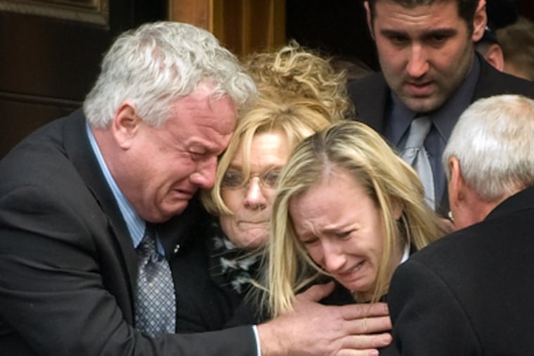 Officer John Pawlowski's widow, Kim (right), five-months pregnant, and her parents Ed and Sharon Leigh, are overcome with grief as they follow the casket out of the cathedral after this afternoon's Funeral Mass. (Clem Murray / Staff Photographer)