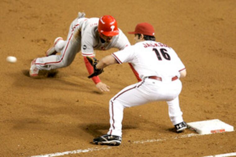 The Phillies' Shane Victorino is picked off first base as Arizona's Conor Jackson awaits the throw. Phils manager Charlie Manuel watched a TV replay of Monday's one-run loss and stood by his decisions. E3.