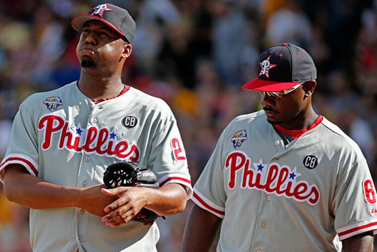 Roberto Hernandez, left, gets a visit from first baseman Ryan Howard (6) during the first inning of a baseball game against the Pittsburgh Pirates in Pittsburgh, Friday, July 4, 2014. (Gene J. Puskar/AP)