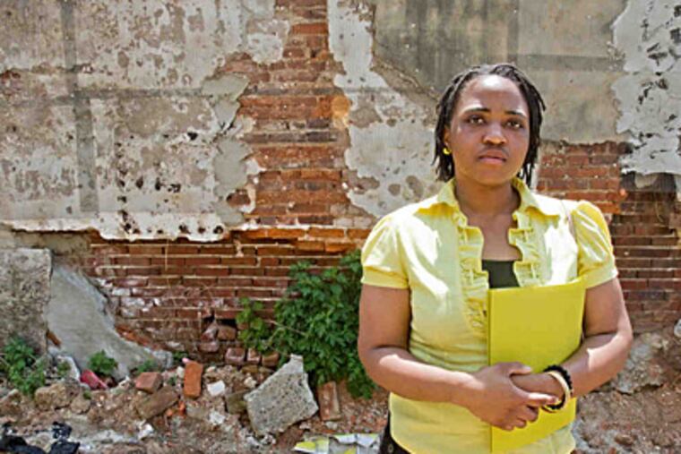 Nashanta Robinson, community advocate and lifelong Philadelphia resident, takes part in the Campaign to Take Back Vacant Land tour. She was at vacant property across from the McKinley School on North Fourth Street. (David M Warren/Staff)