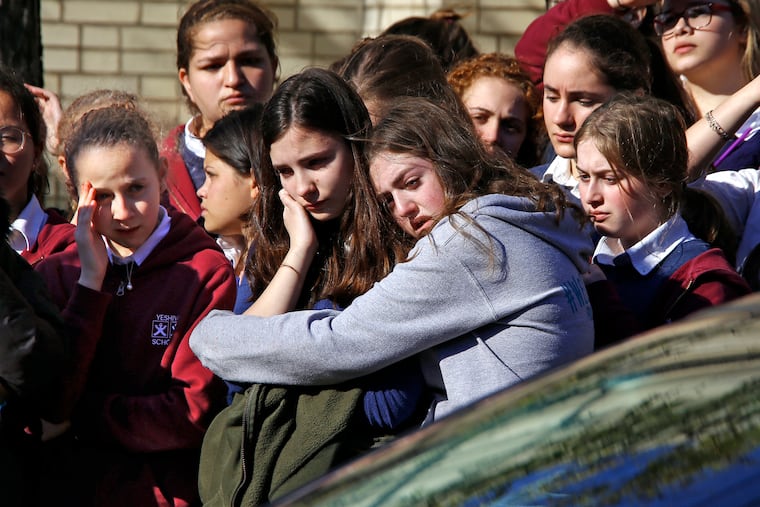 Students from the Yeshiva School in the Squirrel Hill neighborhood of Pittsburgh stand outside Beth Shalom Synagogue after attending the funeral service for Joyce Fienberg, Wednesday, Oct. 31, 2018. Fienberg, 75, Melvin Wax, 87, and Irving Younger, 69, were to be laid to rest as part of a weeklong series of services for the 11 people killed in a shooting rampage at the Tree of Life synagogue Saturday. (AP Photo/Gene J. Puskar)