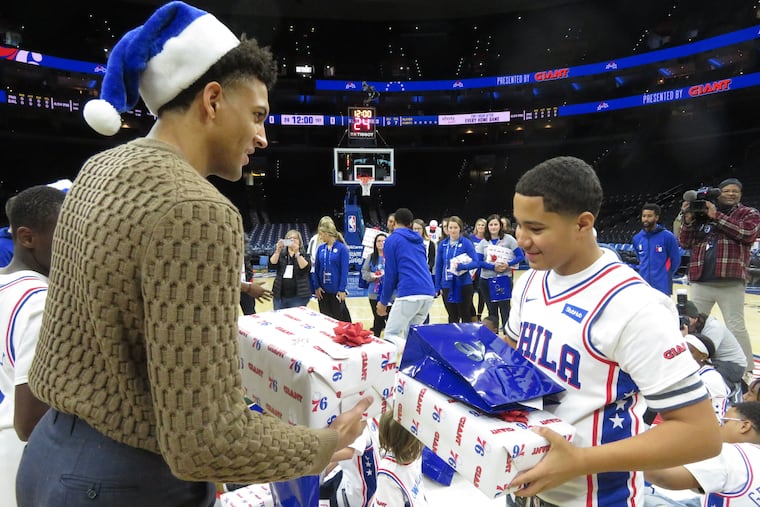 Sixers rookie Matisse Thybulle hands a gift to Yaniel Santiago Delgado of the Boys and Girls Club of Chester. The Sixers hosted 20 youngsters before Friday's game against the Dallas Mavericks and surprised them by giving them gifts.