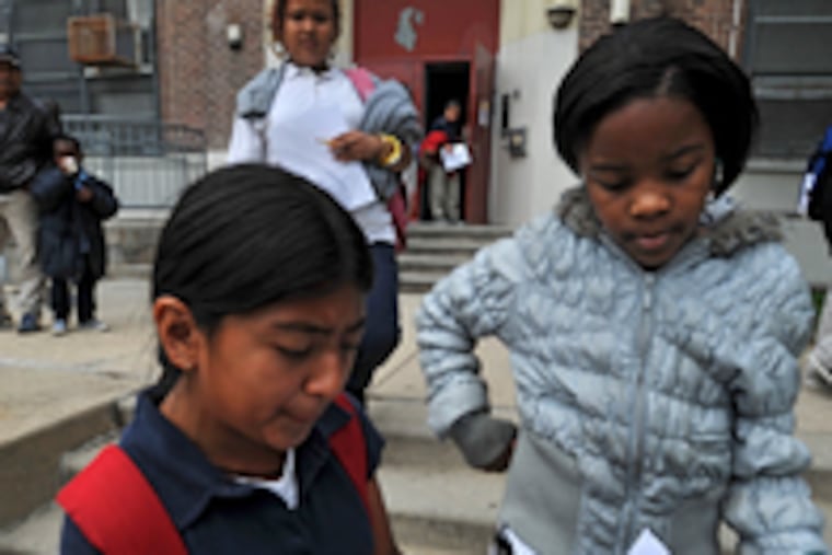 Fifth graders Jessica Medina (left) and Ahmyah Robinson read the superintendent's note on the early dismissal.