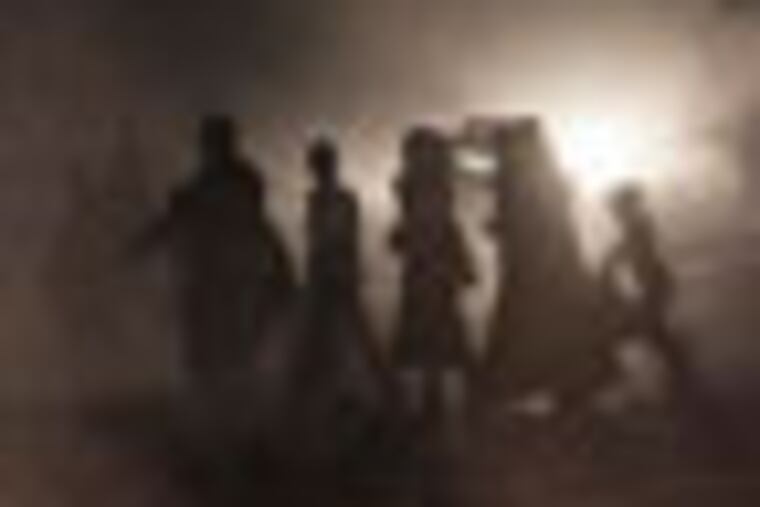 In this Saturday, Oct. 27, 2012 photo, Syrian residents cross a street as a pile of rubbish burns along the roadside in Aleppo, Syria. (AP Photo/Narciso Contreras).