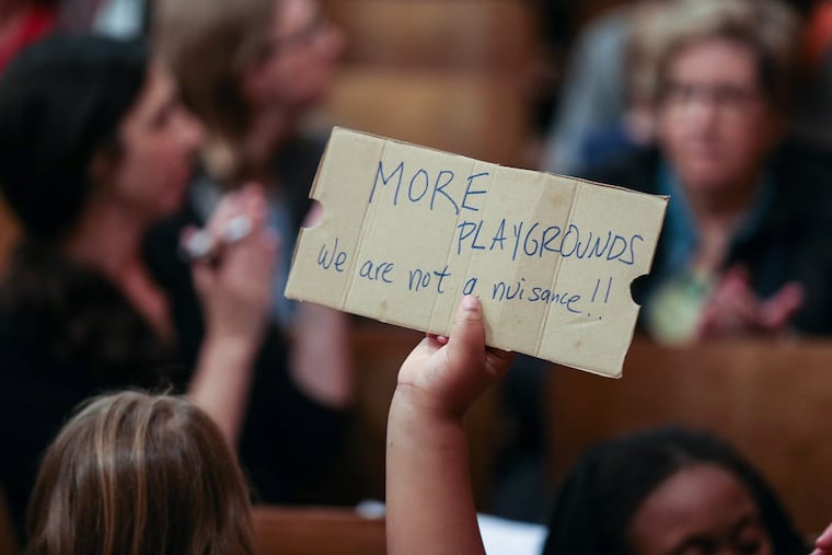 A small hand with a message during the Nebinger Elementary School new playground panel wth the community with neighbors and parents. Thursday, May 25, 2017. STEVEN M. FALK / Staff Photographer