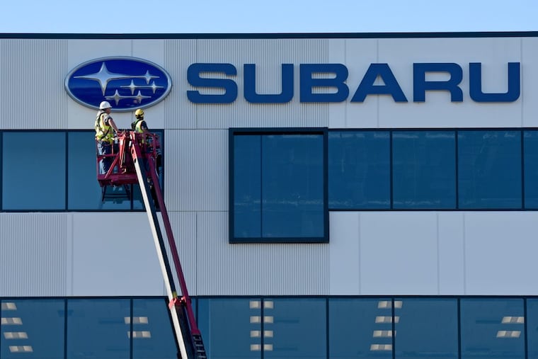 Mike Collins (left) and Frank Calabrese with Philadelphia Sign Co., of Palmyra, finish installing the Subaru logo and sign at the automaker’s still under construction U.S. headquarters in Camden’s Gateway District.