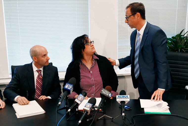Renita Hill, center, who appeared on an educational children's TV show as a teenager with Bill Cosby in the 1980s, sits between two of her attorneys, Ken Haber, left, and George Kontos, at a news conference about a lawsuit against Cosby, Thursday, Oct. 15, 2015, in Pittsburgh.
