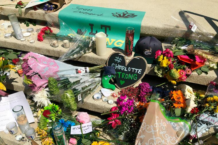 A growing memorial is seen on the steps of a building at the University of North Carolina at Charlotte, Thursday, May 2, 2019. A gunman opened fire in a classroom on Tuesday, killing two and wounding four. (AP Photo/Skip Foreman)