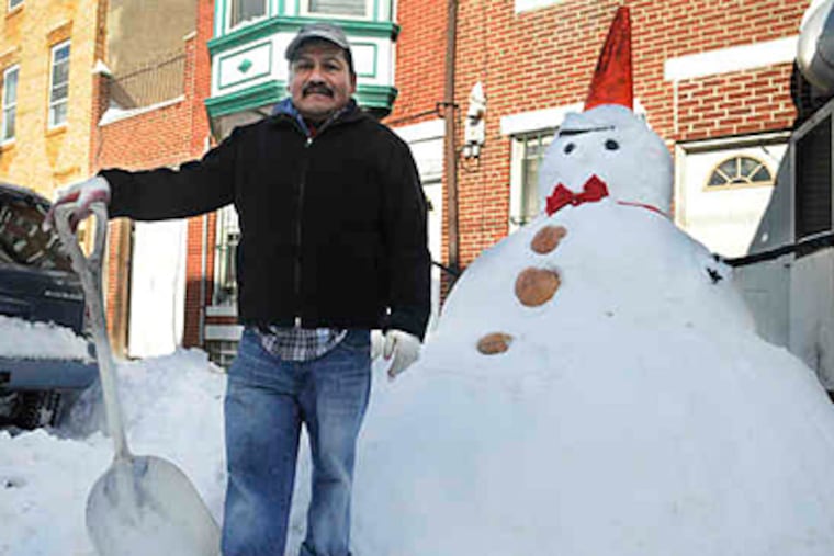 German Guerrero, with the 6-foot snoman he made in South Philly. (Sarah J. Glover / Staff)