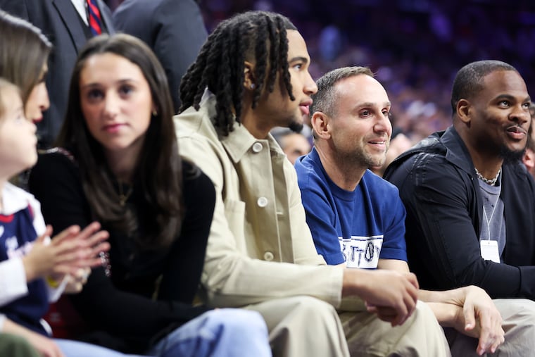 Fanatics CEO Michael Rubin, center, sits with Texans quarterback C. J. Stroud, left, and Cowboys linebacker Micah Parsons during a Sixers playoff game against the Knicks last April.