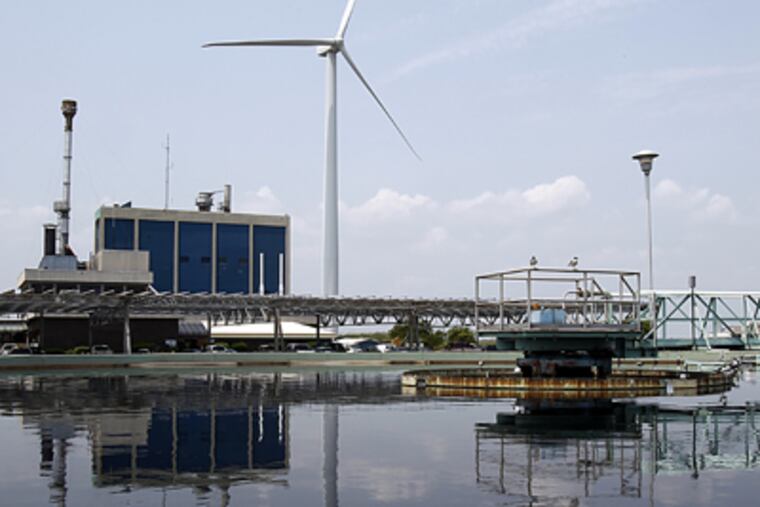 One of five Jersey-Atlantic Wind Farm turbines is reflected in a holding tank at the county wastewater-treatment plant. (Akira Suwa / Staff Photographer)