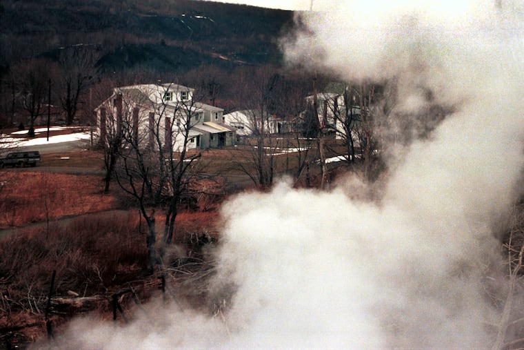 In a 2001 photo, smoke billowed from the mine fire along a hillside overlooking the few remaining homes in Centralia. Today, the fire has moved to the perimeter, so haze no longer clouds the heart of the town. Tourists are lured by horrific stories on the web.