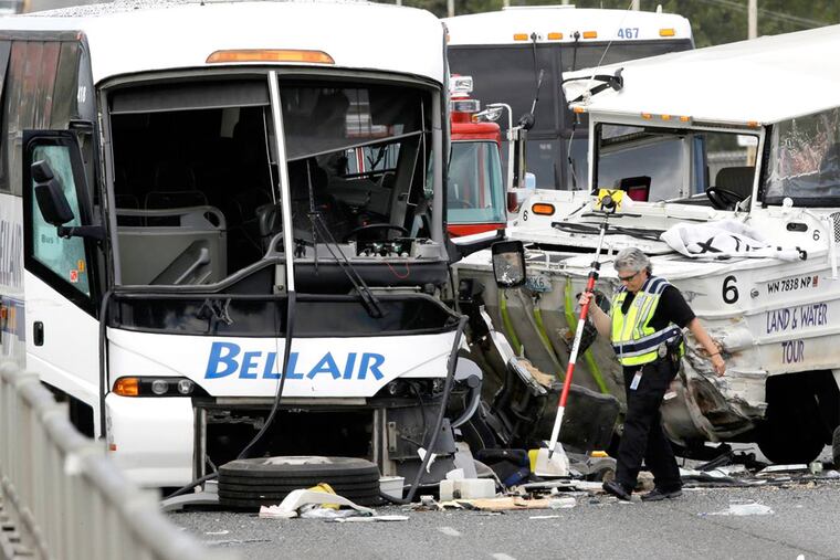 A Seattle official at the scene of a deadly crash involving a "Ride the Ducks" amphibious vehicle, right, and several other vehicles Thursday, Sept. 24, 2015, in Seattle.