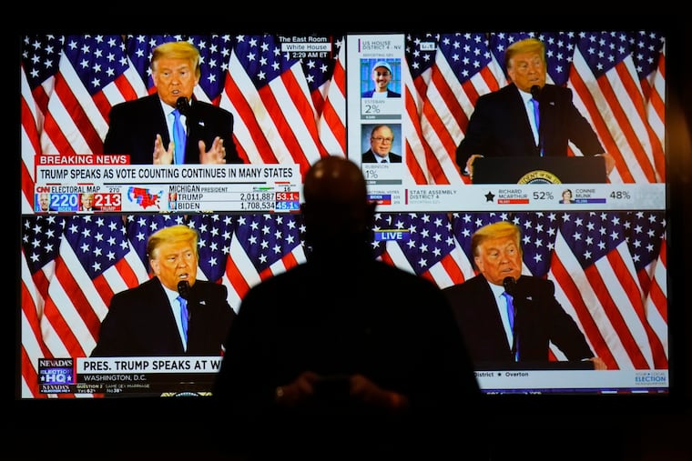 A live broadcast of President Donald Trump speaking from the White House is shown on screens at an election night party in Las Vegas on Nov. 3, 2020.