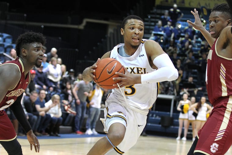 Troy Harper of Drexel driving between College of Charleston defenders on Saturday.