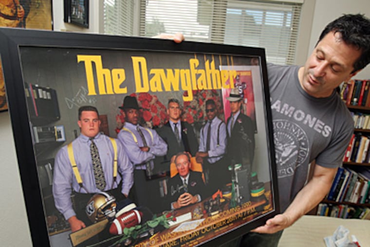 In his Seattle, Washington home on July 13, 2011, John Costacos holds one of the posters he created with his brother of UW football coach Don James with his linemen. The brothers' posters have become almost as legendary as the sports icons they feature. (Ken Lambert/Seattle Times/MCT)