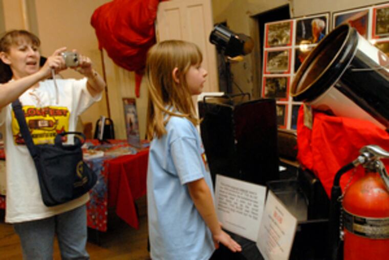 Olivia Dochemetz gets a peek at what the fuss is all about as her great-aunt Josie Boore captures the moment. A canister of substance billed as a blob sample was part of the display at the 12th annual Blobfest, which ended yesterday.