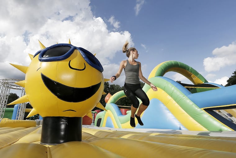Claire Wolters jumps up with the sun in the Big Bouncer at the Big Bounce America The World's Biggest Bounce House in Chester, Pa. on July 5, 2018.