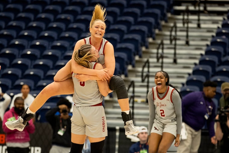 St. Joseph's Laura Ziegler leaps into the arms of teammate Talya Brugler after their overtime victory against Rhode Island in the Atlantic 10 women's basketball quarterfinal in Glen Allen, Va., on Friday.