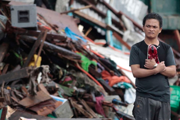 A resident surveys damage wrought by Typhoon Haiyan in the central Philippines city of Tacloban. Friday's storm has displaced an estimated 600,000 people. AARON FAVILA / AP