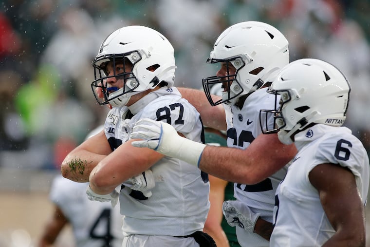 Penn State's Pat Freiermuth (left), Michal Menet (center), and Justin Shorter celebrate Freiermuth's touchdown on a pass reception against Michigan State in the second quarter.