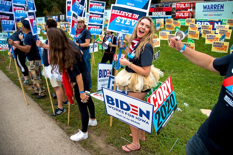 Volunteer Riley Nelson from Colorado Springs supporting Gov. Steven Bullock of Montana greets voters arriving at the Polk County Steak Fry, a huge gathering of Democrats in Des Moines, Iowa, on Sept. 21, 2019.