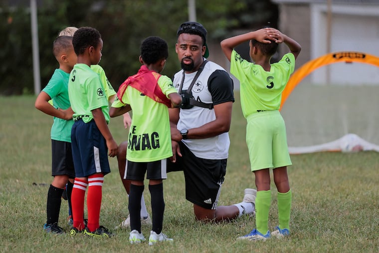Coach Ryan Griffith works with the 6-7 year-olds during SWAG Soccer, a program for inner city and immigrant Philly kids that acts as a funnel to the Union’s academy at the Observatory Field playground in Upper Darby, Monday, August 22, 2022