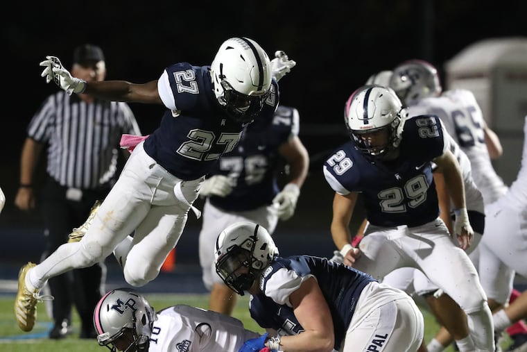 Malcolm Folk (top left) of Episcopal Academy flies over Lonnie White Jr. of Malvern Prep after White was tackled by Max Strid (center) during an Inter-Ac League football game Oct. 25, 2019. Episcopal Academy's Matt Bush is at right.