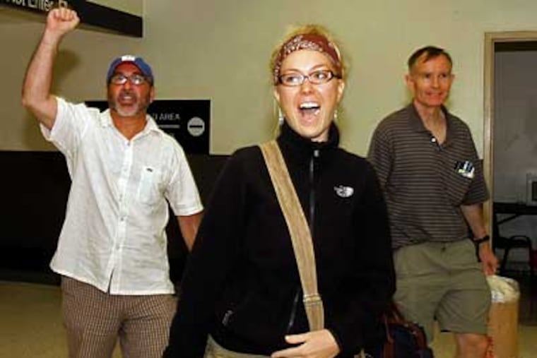 Rev. Patrick Mahoney, left, Brandi Swindell, center, and Mike McMonagle greet supporters upon arrival at Los Angeles International Airport on Thursday in Los Angeles. They were detained by Chinese officials after protesting on Tiananmen Square. (AP Photo/Nick Ut)