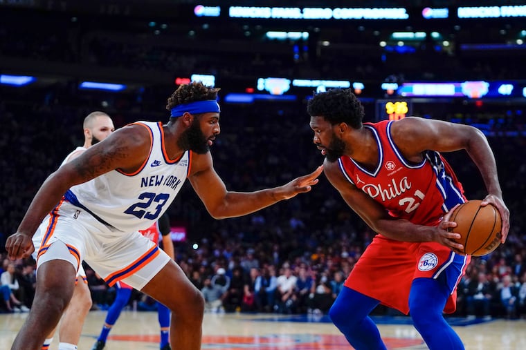 Joel Embiid (right) protects the ball from the Knicks' Mitchell Robinson during the first half Tuesday night.