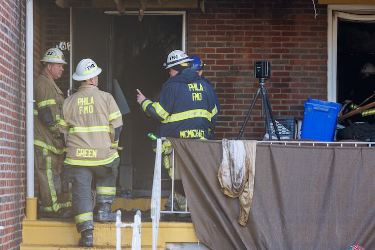 Philadelphia Fire Department personnel investigating fatal rowhouse fire on 6200 block of Ogontz Avenue.
