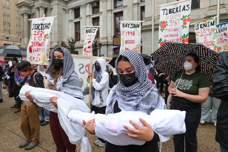 Pro-Palestine protesters hold figures representing children killed in Gaza, during a demonstration at Philadelphia City Hall on Saturday, May 18, 2024.