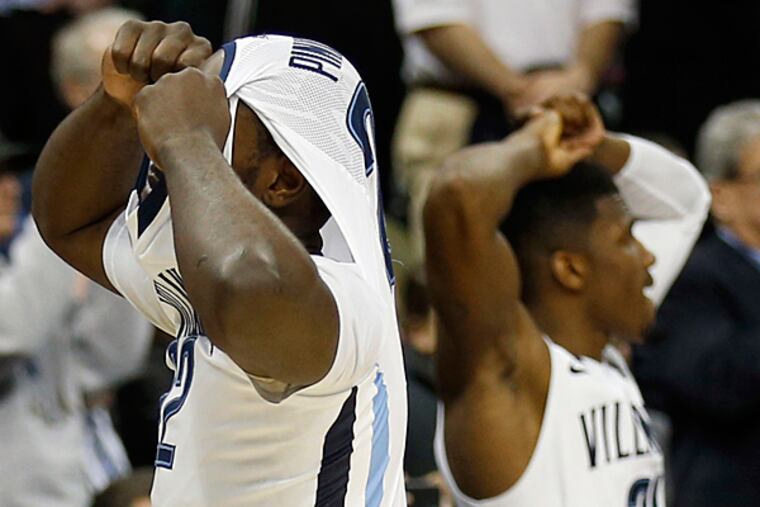 Villanova' JayVaughn Pinkston covers his head with Dylan Ennis after
losing to North Carolina State. (Yong Kim/Staff Photographer)