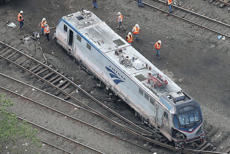 The engine of Amtrak Train 188 rests between sets of railroad tracks after the derailment in May 2015.