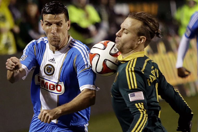 Union forward Sebastien Le Toux, left, and Portland Timbers defender Michael Harrington battle for the ball during the first half of an MLS soccer game in Portland, Ore., Saturday, March 8, 2014. (Don Ryan/AP)