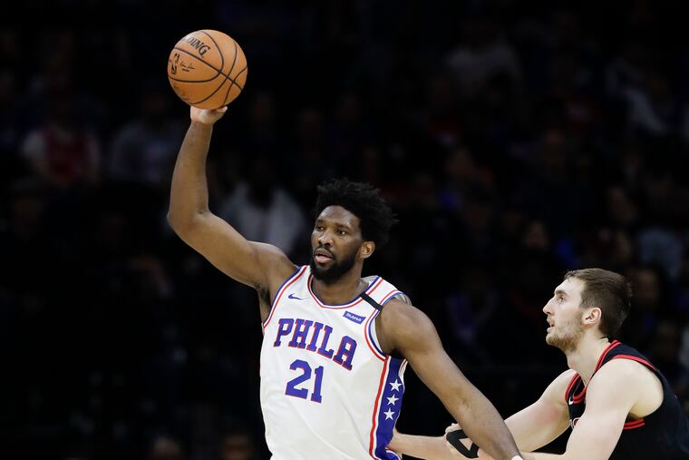 Sixers center Joel Embiid catches the ball in front of Bulls forward Luke Kornet.