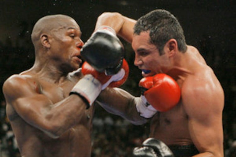 Floyd Mayweather Jr. (left) and Oscar De La Hoya trade inside punches in the 10th round of Saturday's junior-middleweight fight.