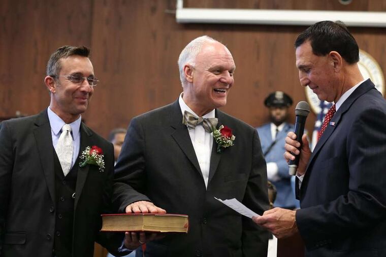 Mayor Don Guardian (center) is sworn in by U.S. Rep. Frank LoBiondo (right). Guardian was accompanied by his partner, Louis Fatato.