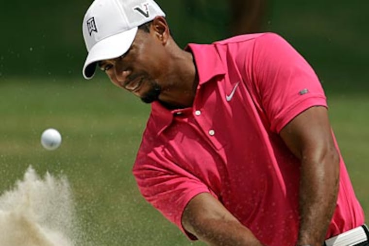 Tiger Woods hits out of a bunker on the ninth hole during the first round of the PGA Championship. (Charlie Riedel/AP)