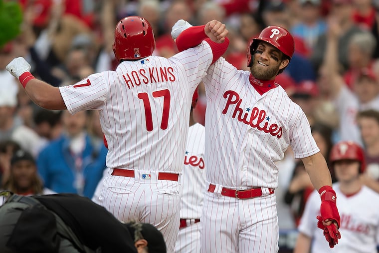 The Braves walked Bryce Harper (right) to get to Rhys Hoskins during the Phillies' opening-day game. Hoskins hit a grand slam to put the Phillies up big and lead them to the win.